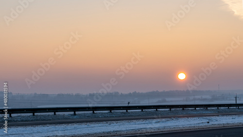 Winter landscape in snow nature with sun  field and trees. Magical winter sunset in a snow field.