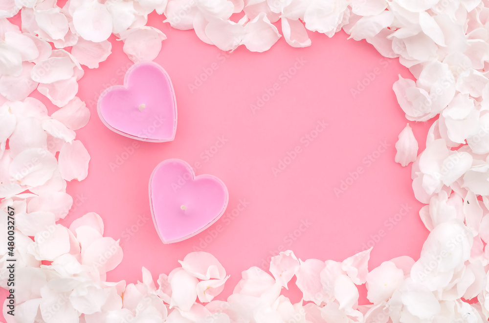 Valentines day pink background with heart shaped candles and flower petals with copy space, spa treatment theme