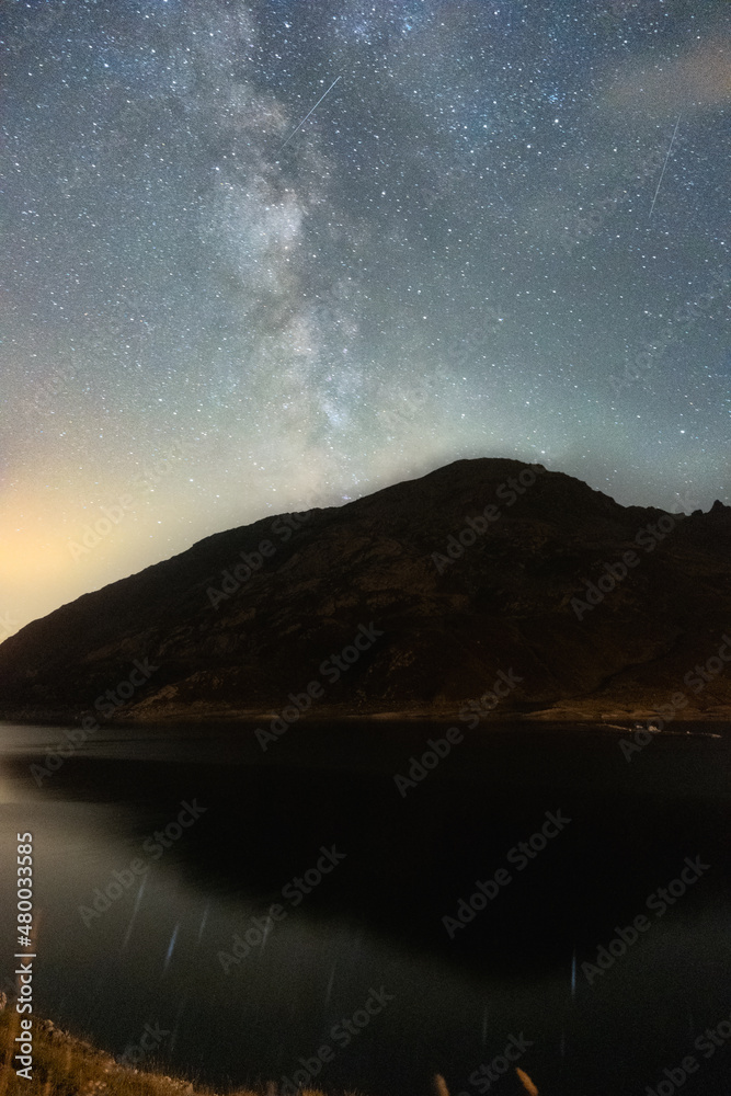 Night landscape with the Milky Way above a mountain and a lake