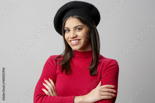 Portrait of attractive young woman in red dress and black beret.