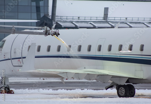 Deicing an airplane in winter, spraying an airplane with an anti-icing liquid in winter photo