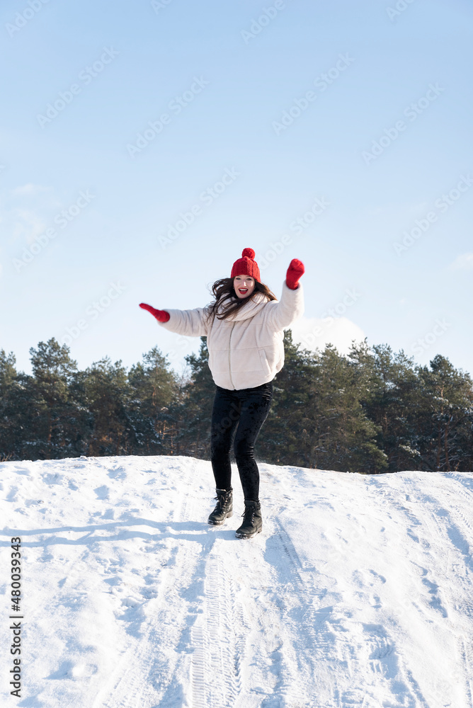 Young beautiful brunette woman slides from a snow slide. Winter sunny day. Vertical frame