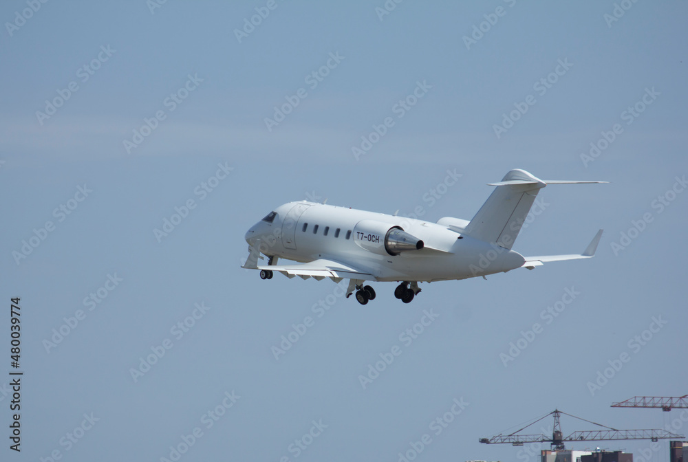 Private white jet plane takes off from the airport against the backdrop of a clear sky during the day Private white jet plane takes off from the airport against the backdrop of a clear sky during the day