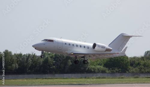 Private white jet plane takes off from the airport against the backdrop of a clear sky during the day