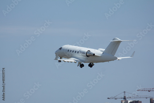 Private white jet plane takes off from the airport against the backdrop of a clear sky during the day