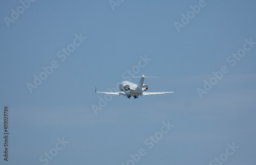 Private white jet plane takes off from the airport against the backdrop of a clear sky during the day