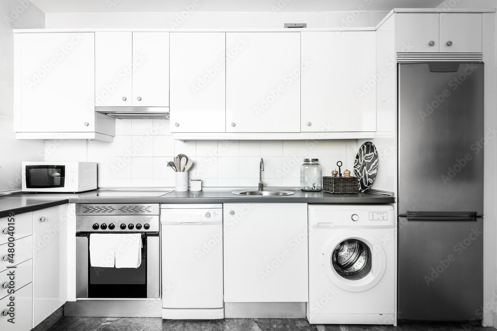 Kitchen with white cabinets and appliances in a vacation rental apartment