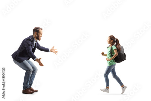 Full length profile shot of a girl with a backpack running towards a man with arms wide open