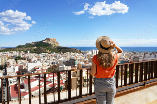 Traveler girl enjoying view of Alicante cityscape and Mount Benacantil with Santa Barbara Castle and sea on background, Spain