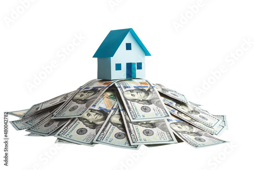 Model of a house on a pile of one hundred dollar bills isolated on white background