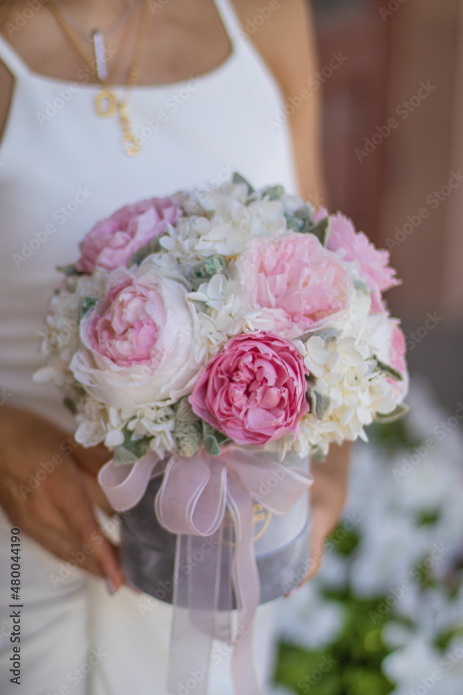Girl holding beautiful mix pink and white peonies flowers in grey round box in womans hands for flowers store. Floral shop concept. Girl holding beautiful mix pink and white peonies flowers in grey round box in womans hands for flowers store. Floral shop concept.
