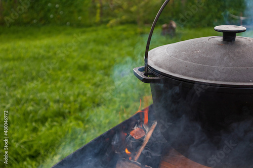 outdoor cooking in a pot, preparing food in a summer camp kitchen