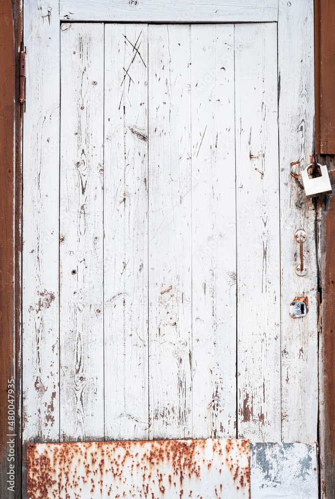 Abandoned house door texture background. Locked wooden entrance with old fashion metal padlock. Blue, white and brown peeled off paint. Security and safety concept. Vertical, close up, copy space Abandoned house door texture background. Locked wooden entrance with old fashion metal padlock. Blue, white and brown peeled off paint. Security and safety concept. Vertical, close up, copy space