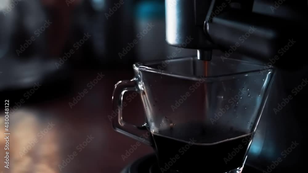 Detalle de cafe en grano cayendo a una taza. Es un café expresso