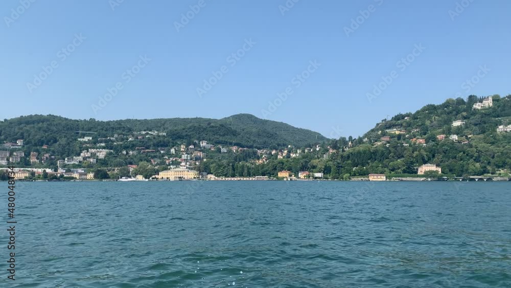 Skyline of Cernobbio town from a moving boat. Panoramic view of Lago di Como lake shore. Summer time at famous vacation destination. Cernobbio, Lake Como, Lombardy, Italy Skyline of Cernobbio town from a moving boat. Panoramic view of Lago di Como lake shore. Summer time at famous vacation destination. Cernobbio, Lake Como, Lombardy, Italy