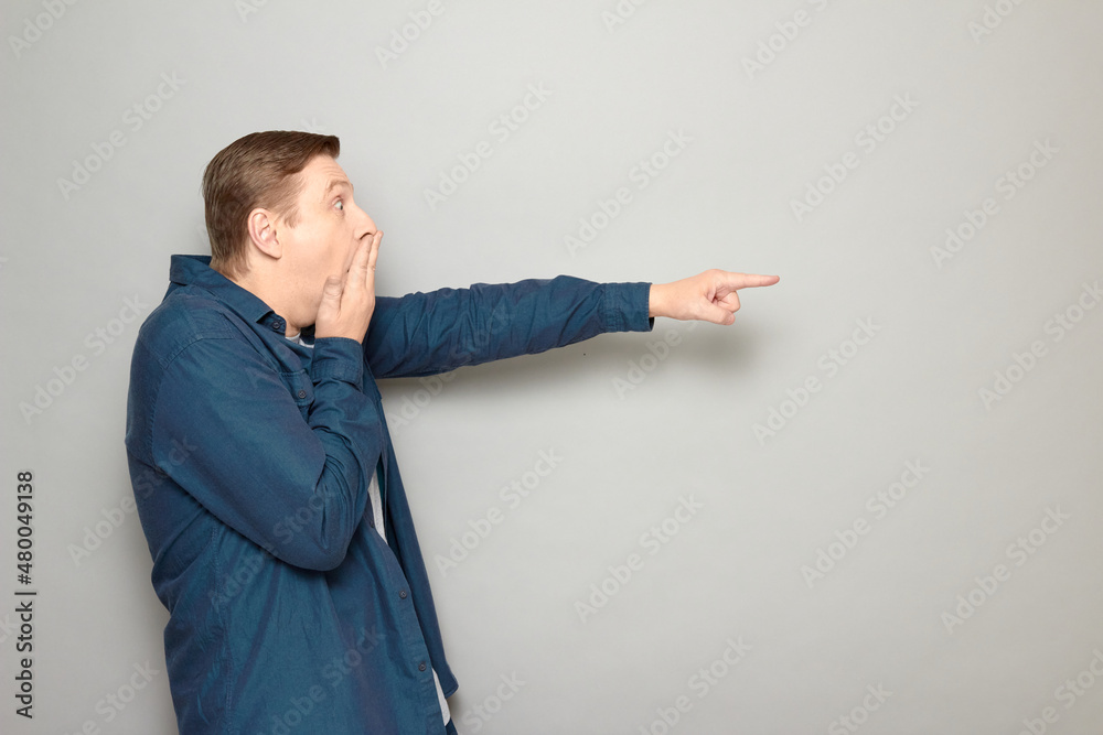 Portrait of shocked frightened man pointing at something awful Portrait of shocked frightened man pointing at something awful