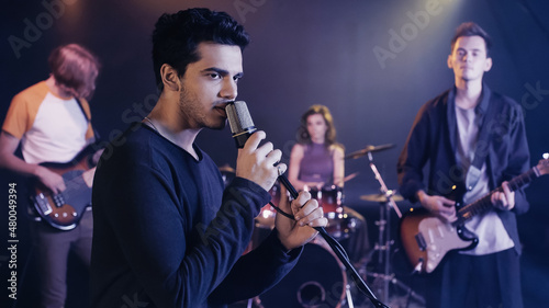 young singer performing song with music band.