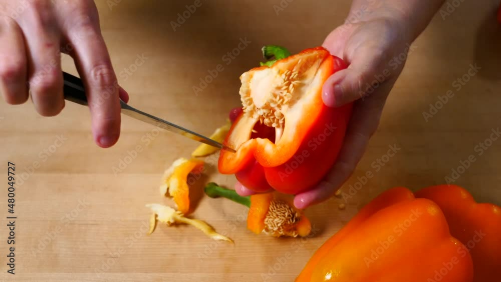 Cutting Orange Pepper on Wooden Cutting Board Cutting Orange Pepper on Wooden Cutting Board