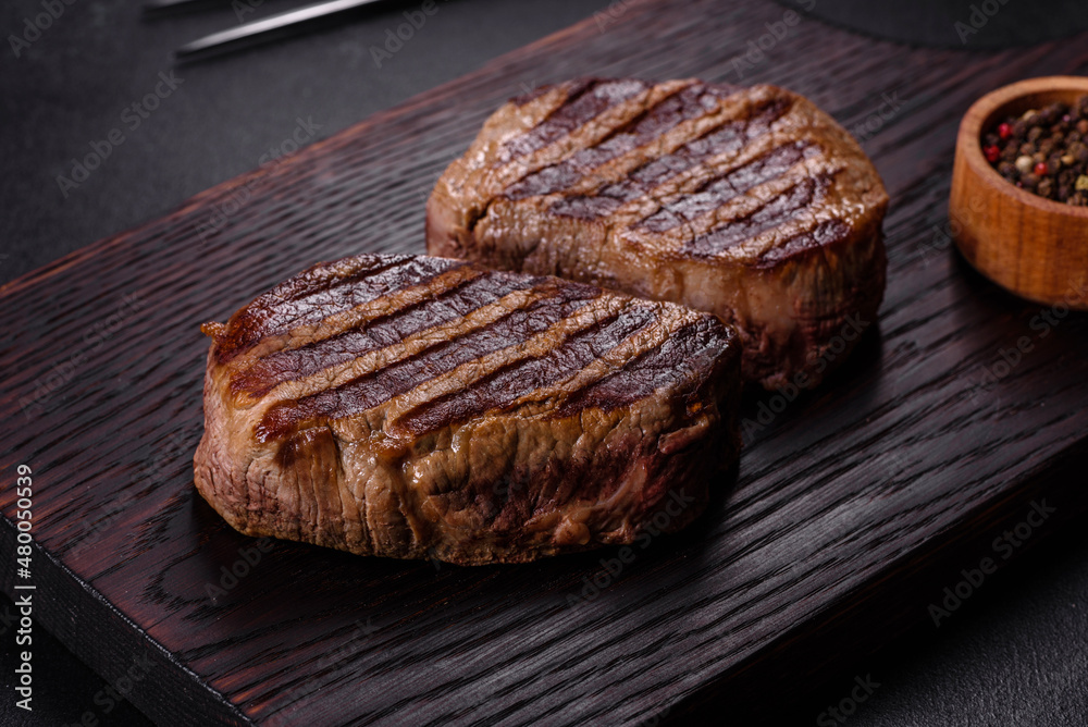 Fresh juicy delicious beef steak on a dark background Fresh juicy delicious beef steak on a dark background
