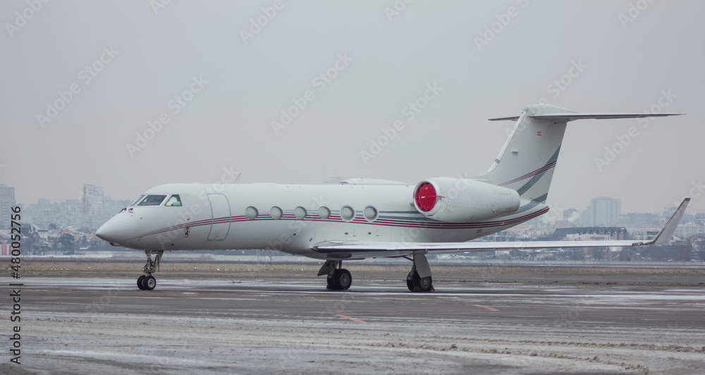 Private jet airliner parked at the airport in cloudy weather Private jet airliner parked at the airport in cloudy weather