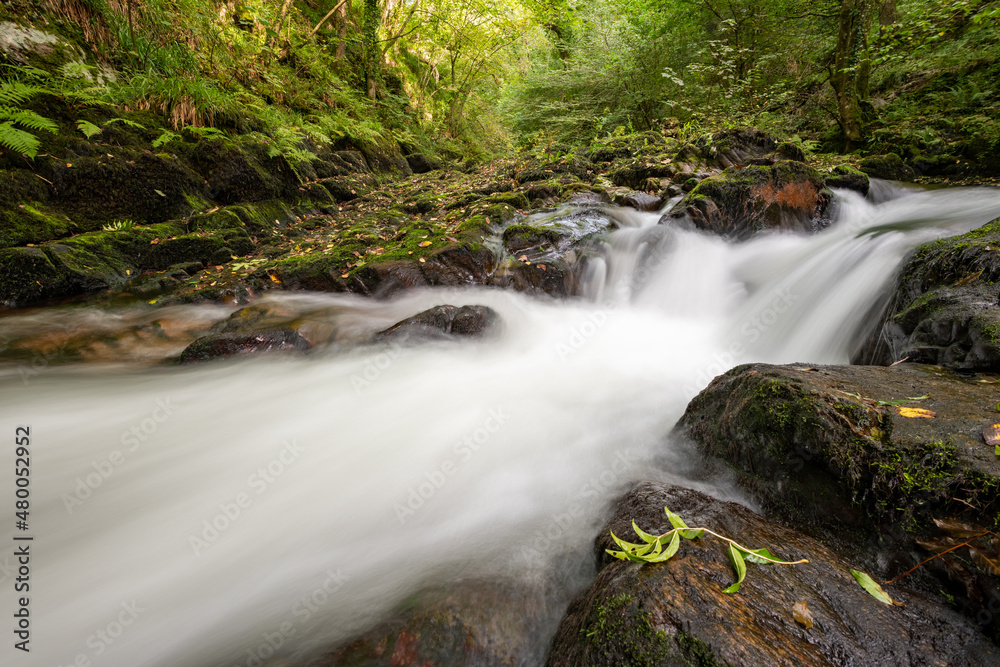 Long exposure of a waterfall on the East Lyn River at Watersmeet in Exmoor National Park Long exposure of a waterfall on the East Lyn River at Watersmeet in Exmoor National Park