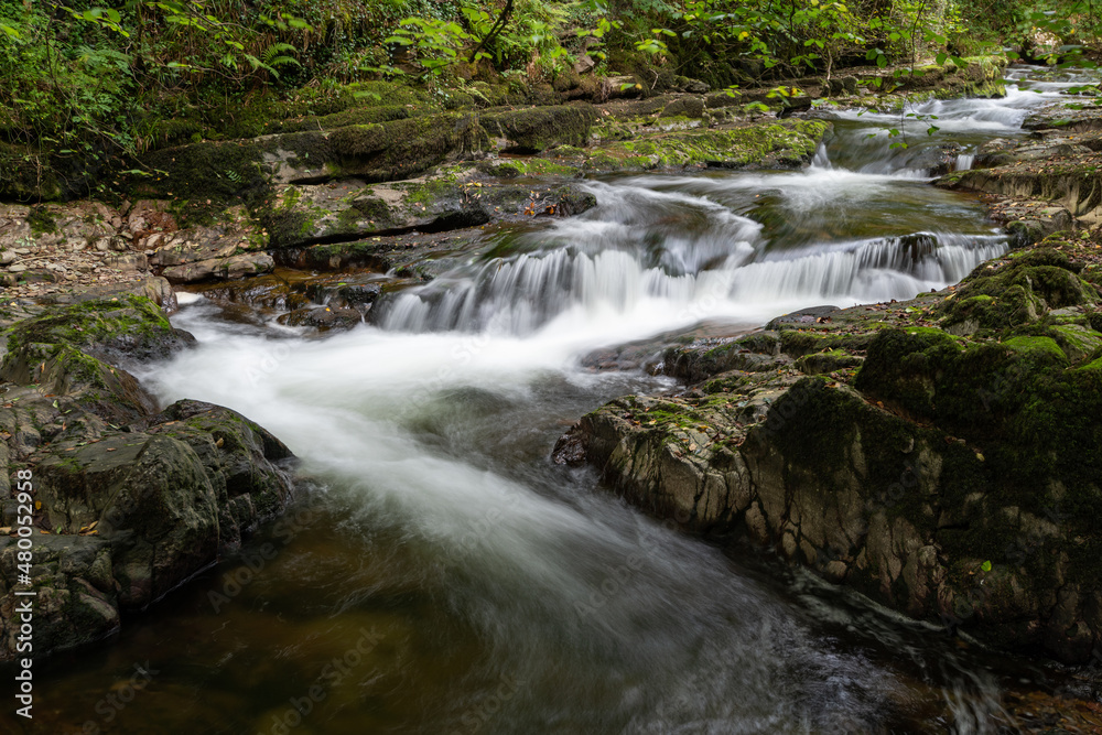 Long exposure of a waterfall on the East Lyn River at Watersmeet in Exmoor National Park Long exposure of a waterfall on the East Lyn River at Watersmeet in Exmoor National Park