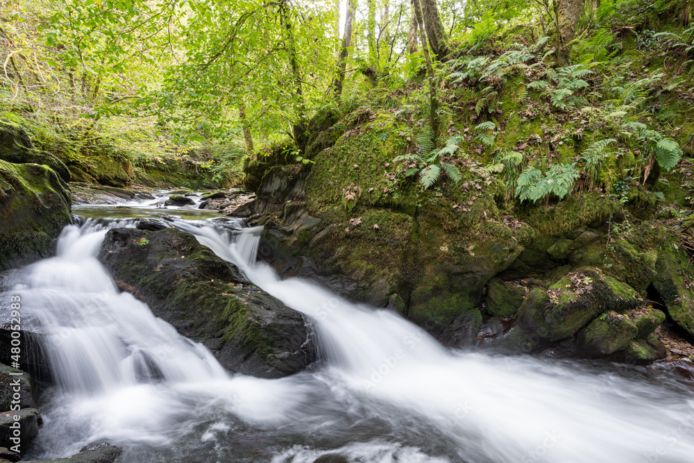 Long exposure of a waterfall on the East Lyn River at Watersmeet in Exmoor National Park Long exposure of a waterfall on the East Lyn River at Watersmeet in Exmoor National Park