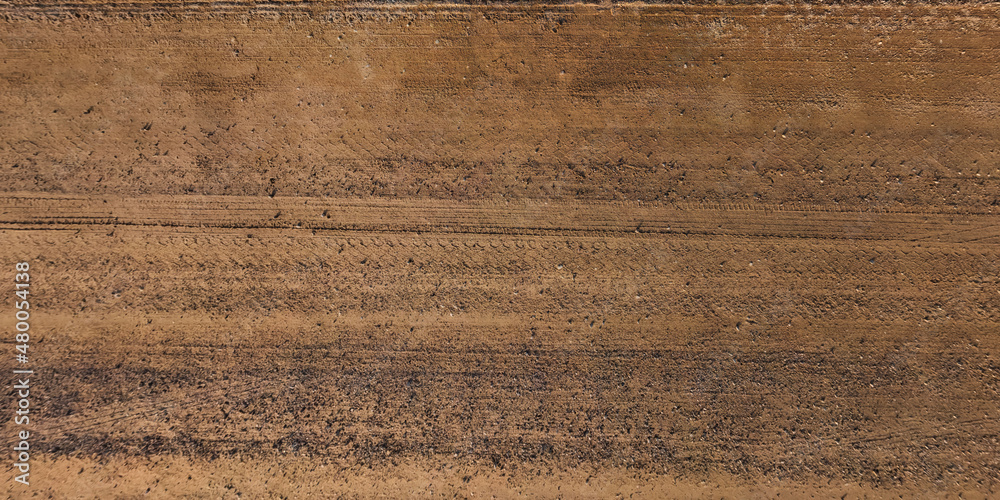 panorama of surface from above of gravel road with car tire tracks panorama of surface from above of gravel road with car tire tracks
