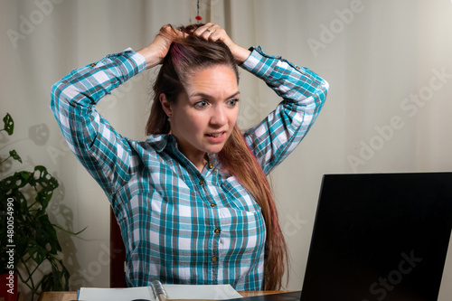 Mujer teniendo problemas con su computadora mientras trabaja photo