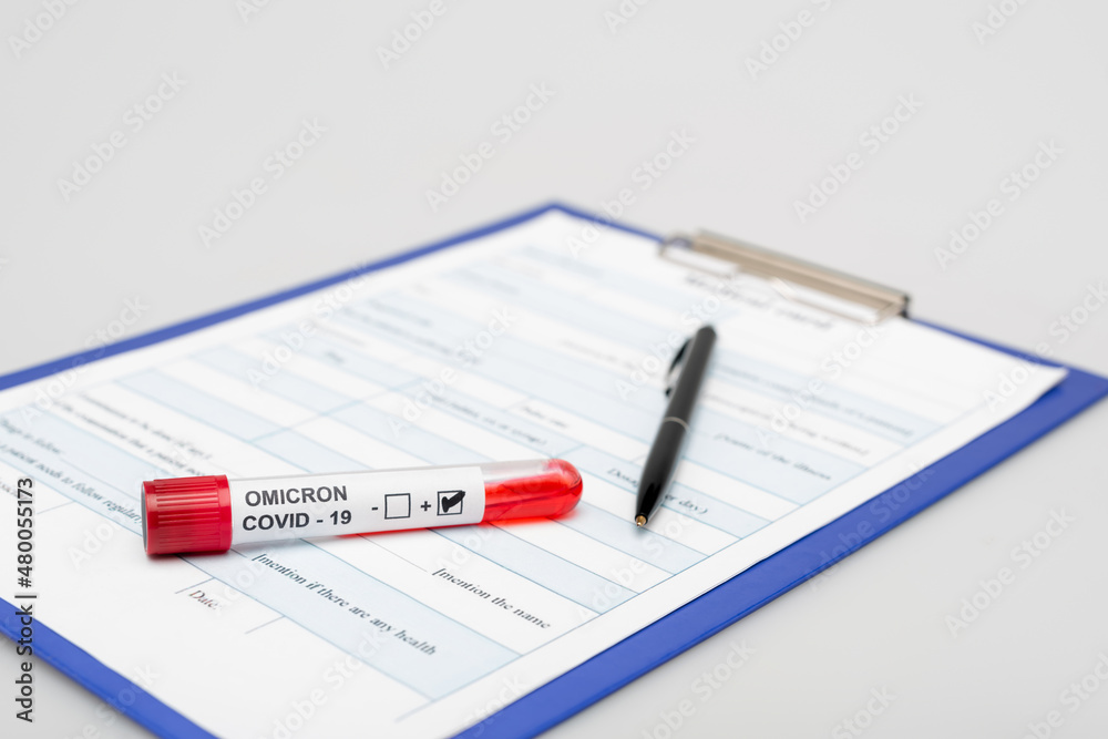clipboard with medical card, covid-19 omicron variant test tube and pen on gray background. clipboard with medical card, covid-19 omicron variant test tube and pen on gray background.