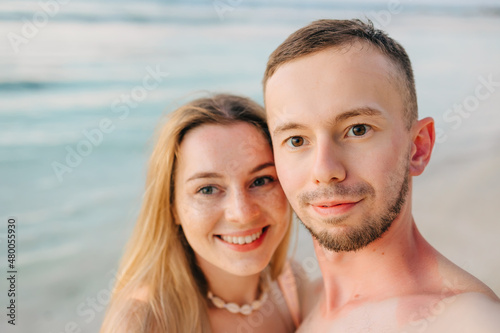 Beautiful couple in love doing self on a tropical beach, enjoy the holidays, sunbathe and have fun. © Ivan