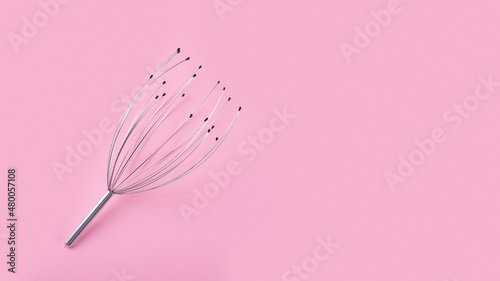 Manual head and neck massager isolated on pink background. Home use acupuncture point head scalp octopus massager