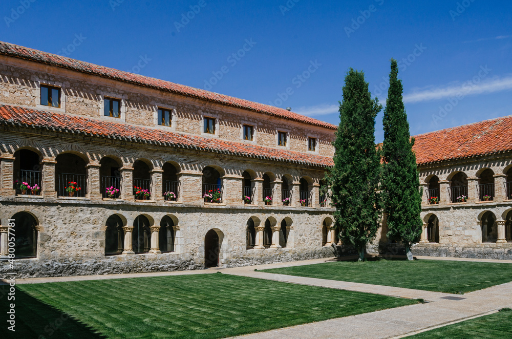 Corner of the courtyard of the convent of Santo Domingo in Caleruega with two large cypress trees, Burgos, Castilla y León, Spain.