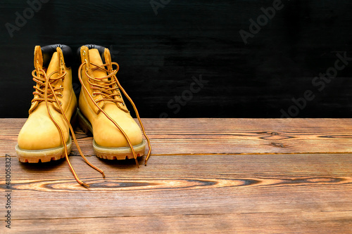 New beautiful brown yellow warm mountain women's winter Timberland tracking shoes, boots, sneakers, trainers logo on wooden background.Sport casual footwear concept. Kyiv, Ukraine-December 20, 2021