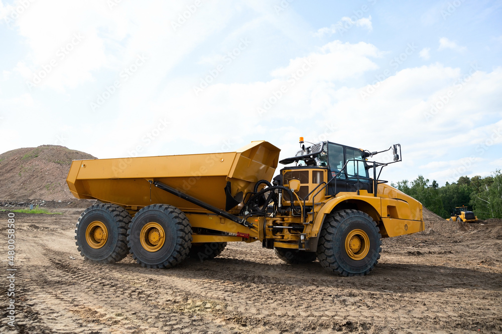 Yellow dump truck damper on the road construction site Yellow dump truck damper on the road construction site