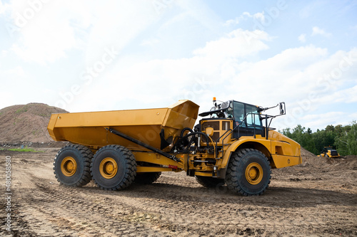 Yellow dump truck damper on the road construction site