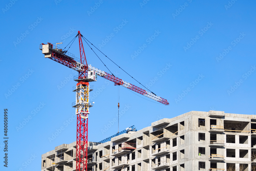 Tower crane and residential apartment building under construction Tower crane and residential apartment building under construction