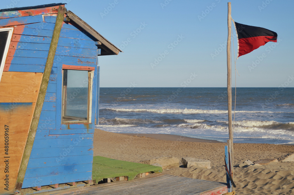 Torre estación mirador de salvavidas en el mar y bandera de advertencia mar peligroso