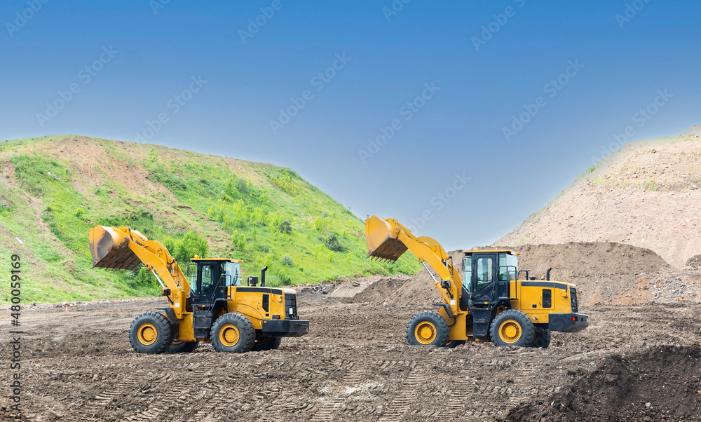 Wheel loaders on the road construction site Wheel loaders on the road construction site
