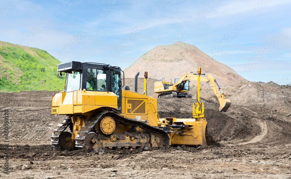 Bulldozer and excavator on the construction site