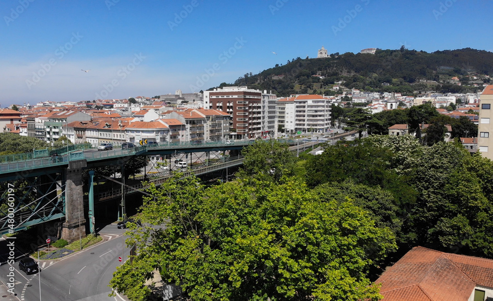 Fototapeta premium Viana do Castelo, Portugal, June 10, 2021: The Gustave Eiffel Bridge over the river Lima in Viana do Castelo. Aerial panoramic cityscape view of Viana and the Marina.