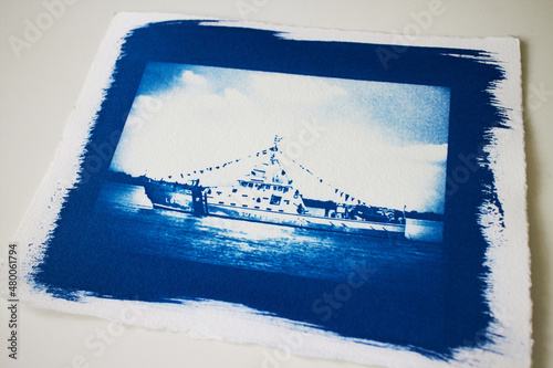 A cyanotype print sheet of a boat in the river isolated on white background. photo