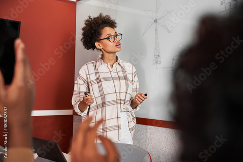 Future bloggers discussing new methodic while standing at modern classroom near the board