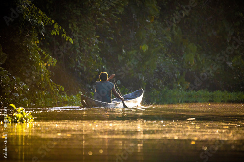 Scenic view of fisherman in canoe at sunrise on the river