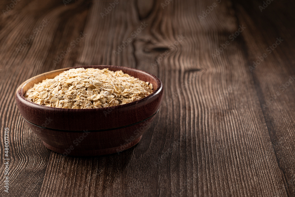 Oat flakes in wooden bowl. Oat flakes in wooden bowl.