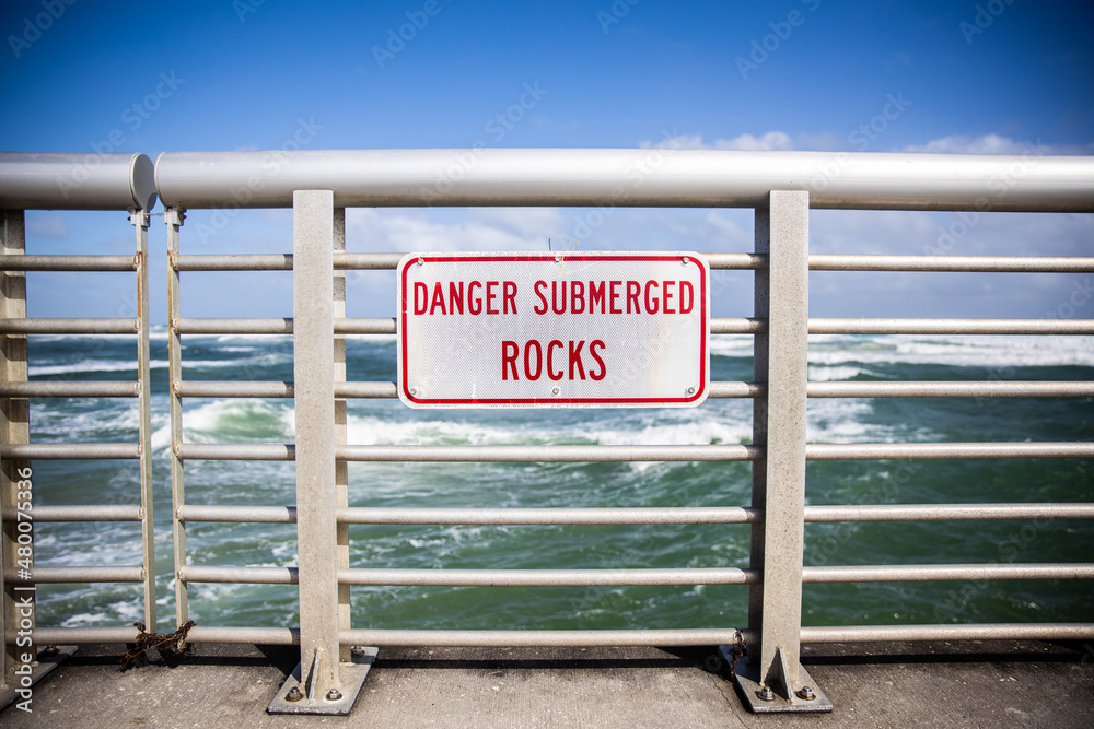 Danger Submerged rocks on safety railing Danger Submerged rocks on safety railing