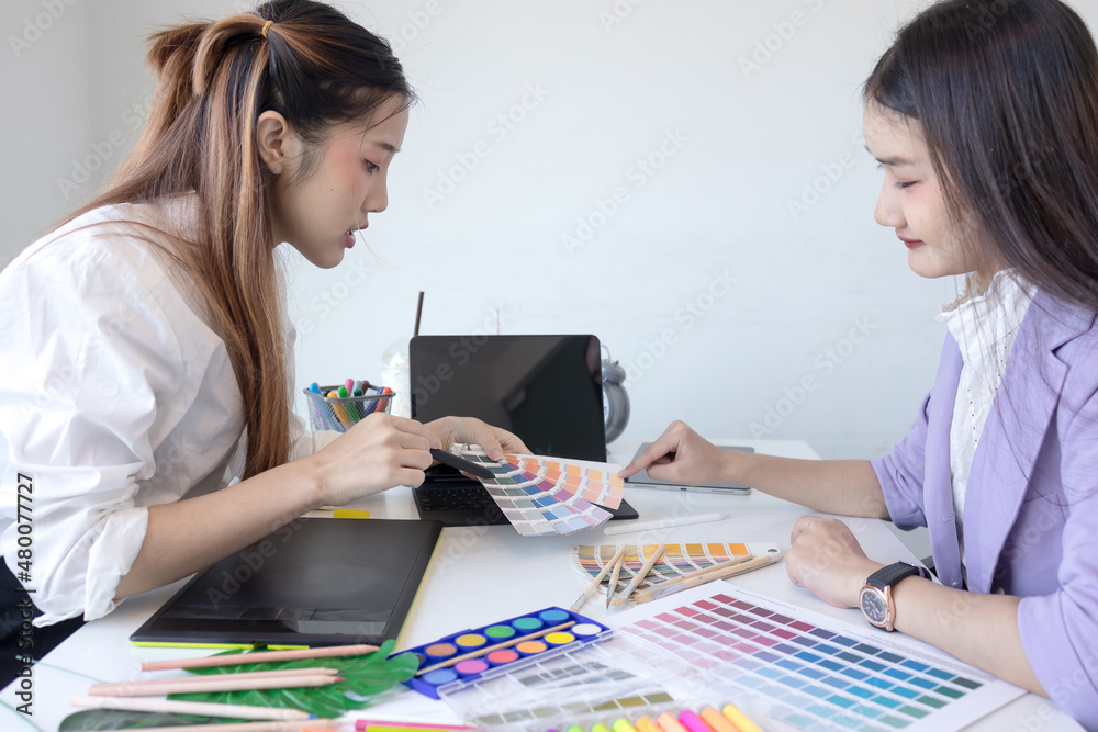 Women designer consulting a client looking at a color swatch. Interior designer presenting choosing samples of paint. Women designer consulting a client looking at a color swatch. Interior designer presenting choosing samples of paint.