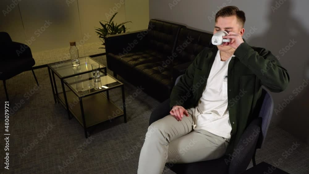 a caucasian man sitting in his office chair drinking coffee - still shot a caucasian man sitting in his office chair drinking coffee - still shot
