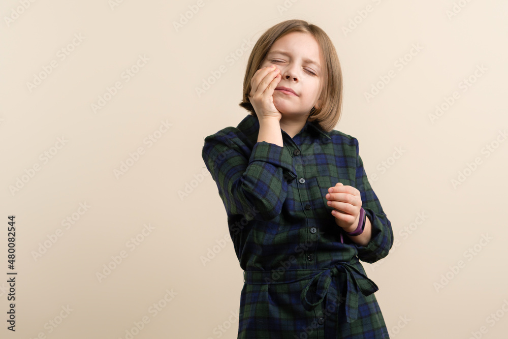 Child has a toothache. Kid Little Girl 9s Wearing Plaid Shirt Dress feeling sick and stressed. Health problem. Healthcare And Medicine Concept. Space for text