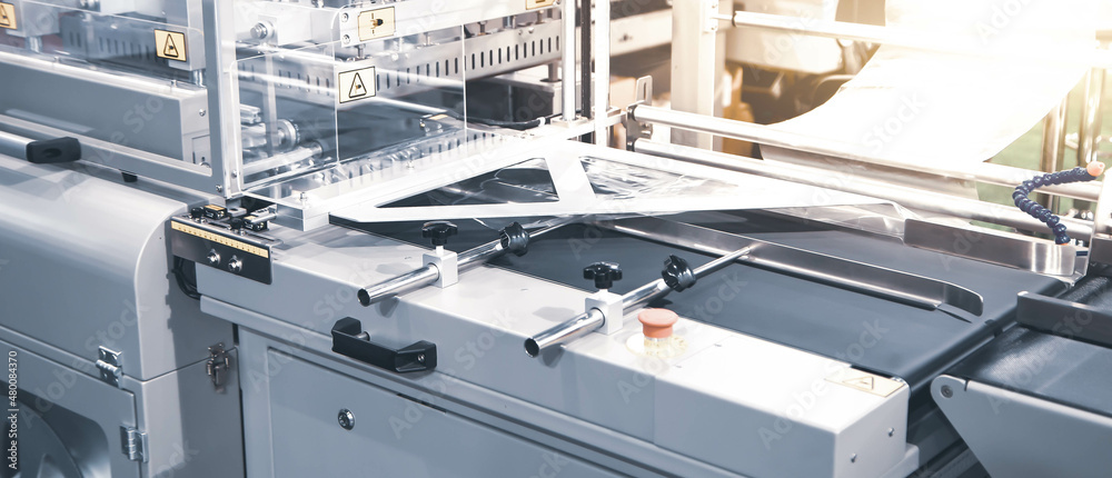 Package shrink film wraping machine in modern warehouse. Package shrink film wraping machine in modern warehouse.